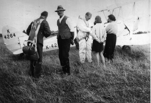 The RAF pilot of a dH.82a Tiger Moth prepares to fly Mr Rolf Pasold as a guest.