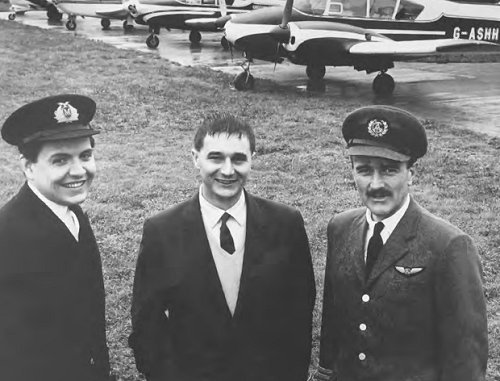 Ken Gregory, centre, in happier times at Denham in the early 1960s with two of his pilots and a number of his aircraft.