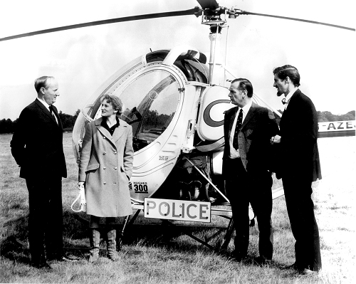 Mike Smith of Air Gregory (furthest right) and aerodrome manager Beatrice Paul (second from left) met with senior police officers to demonstrate the Hughes helicopters of Air Gregory in July 1973.