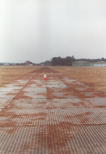 The view along the new taxiway from the runway toward the hangars. The mat forming the surface can be clearly seen.