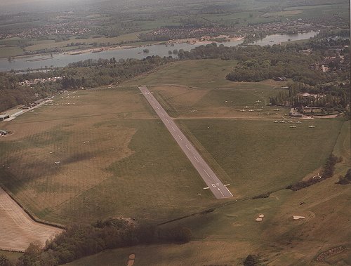 A view across the aerodrome from the west in late 1984. The new radio room is visible on the south side buildings but construction of the Air Training Corps building has not yet begun.