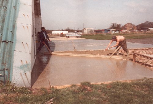 The apron of the blister hangar was repaired in 1985 to provide safer use of the hangar. Here Jimmy James and a colleague are working on smoothing the concrete.