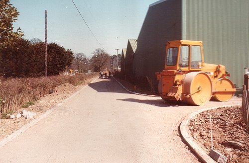 Looking east along hangar road with the kerbs complete and the stone roadbed being rolled smooth.